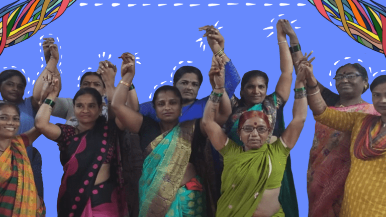 On a rectangle blue background, there are colourful story threads at the edges at the top of the image. In the centre is an image of a group of women, dressed in colour sarees, aand bangles, holding each other's hands, raising them up to signify their solidarity, their sense of community. Below the image is a black box that says, 'Community'.